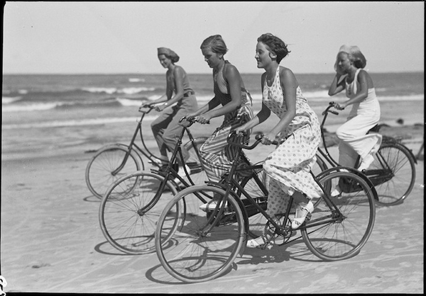 Cyklende ungdom paa stranden